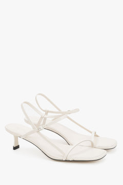 Women’s white leather low-heel sandals by Estro with thin straps.