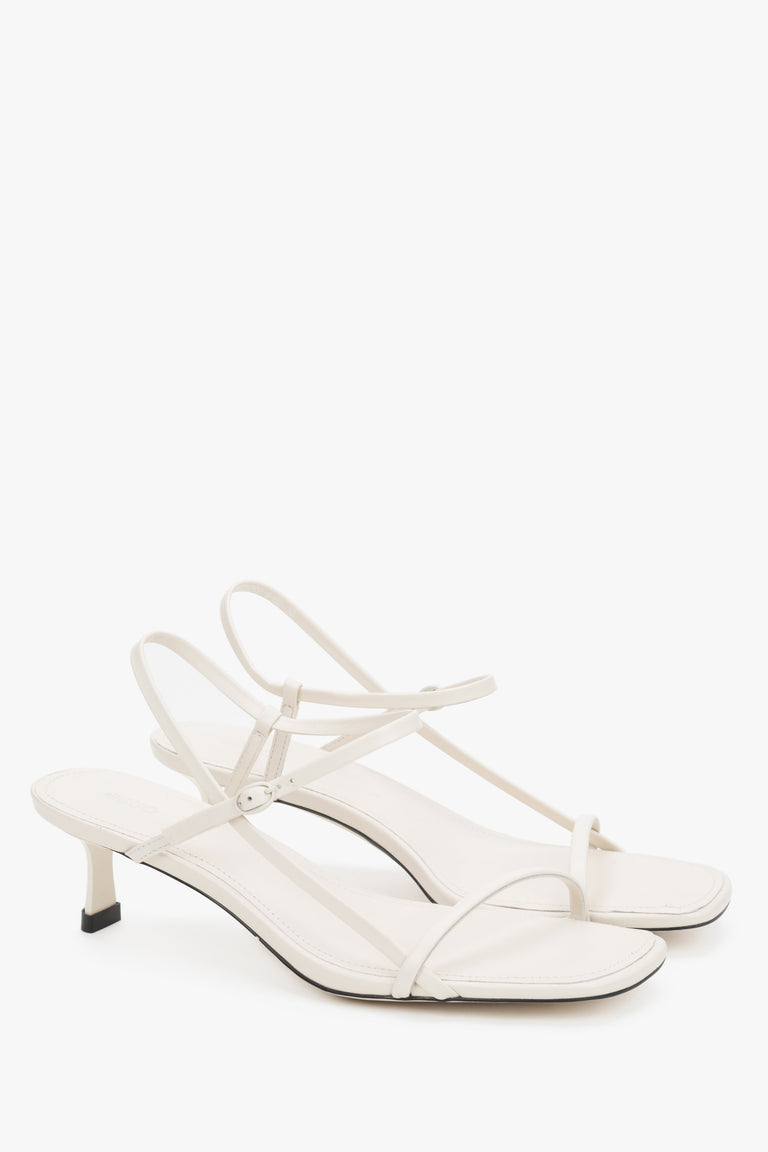 Women’s white leather low-heel sandals by Estro with thin straps.