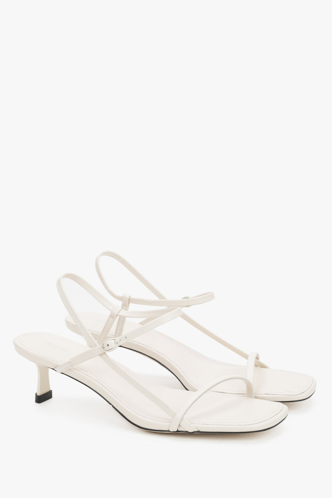 Women’s white leather low-heel sandals by Estro with thin straps.