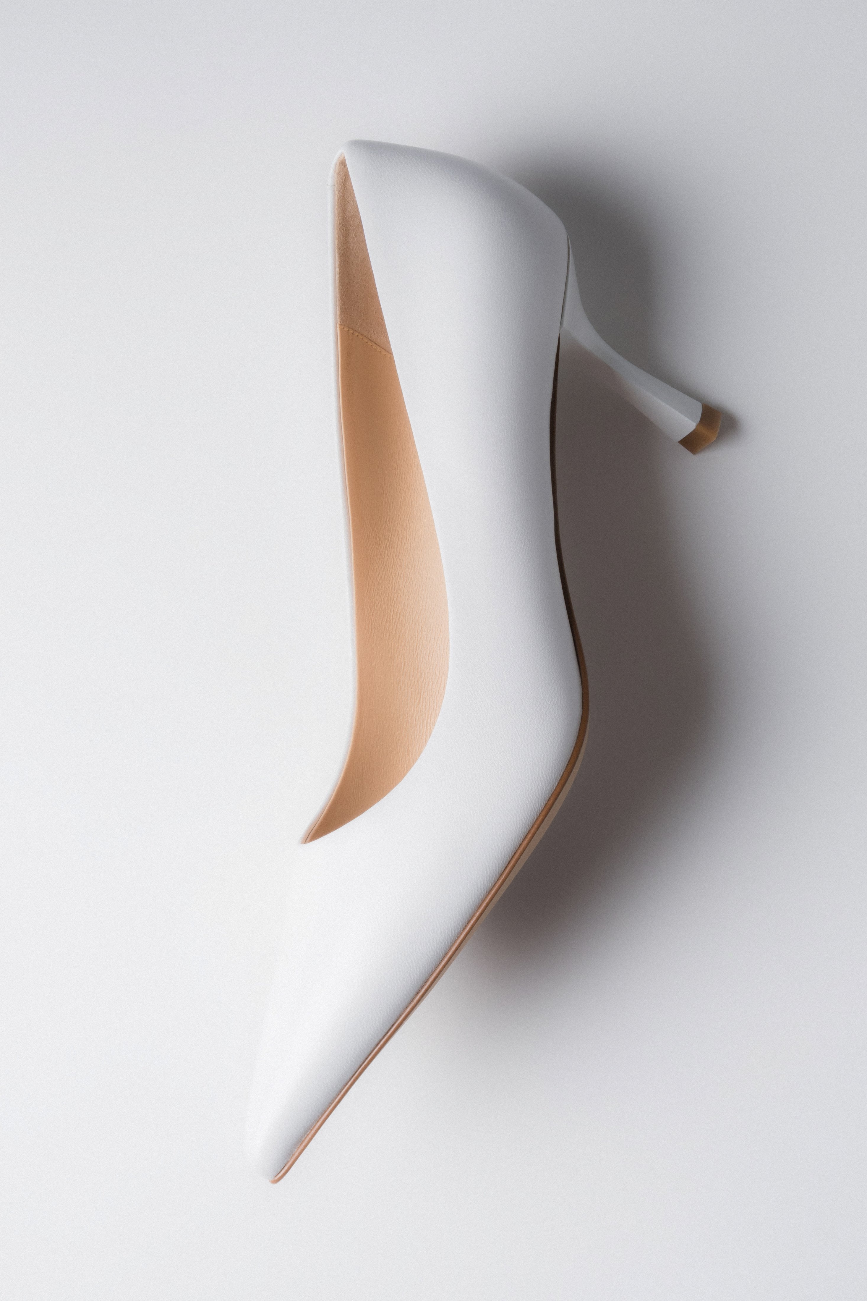 Low-heeled women's pumps in white.