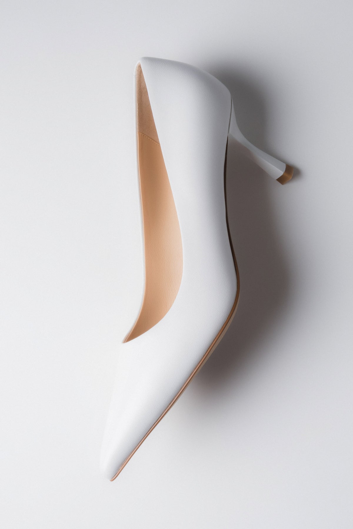 Low-heeled women's pumps in white.