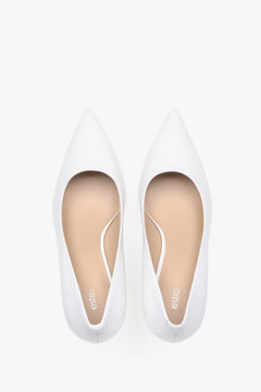 Top view of white leather low-heeled shoes.