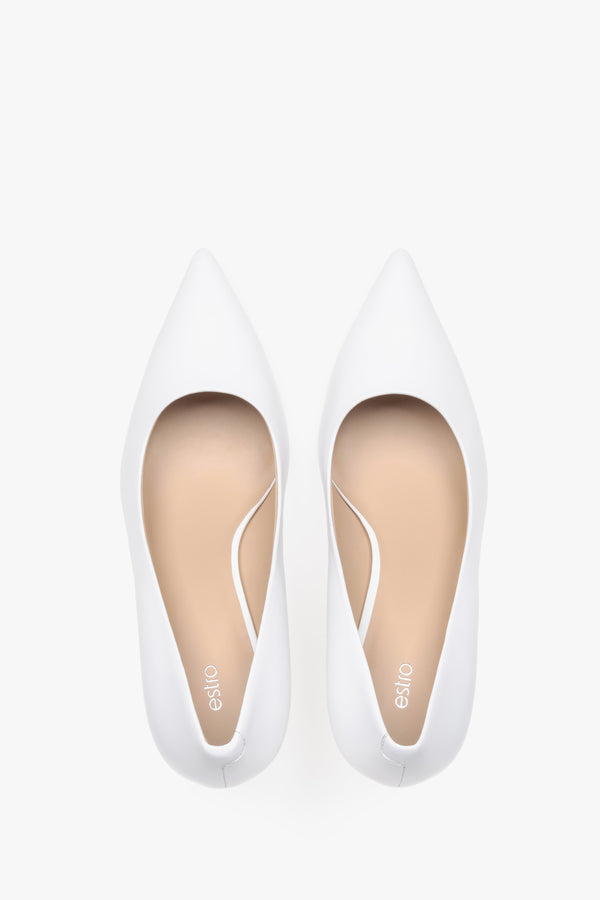 Top view of white leather low-heeled shoes.