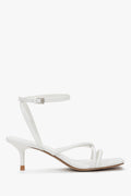 Women's white leather stiletto sandals by Estro with thin straps.