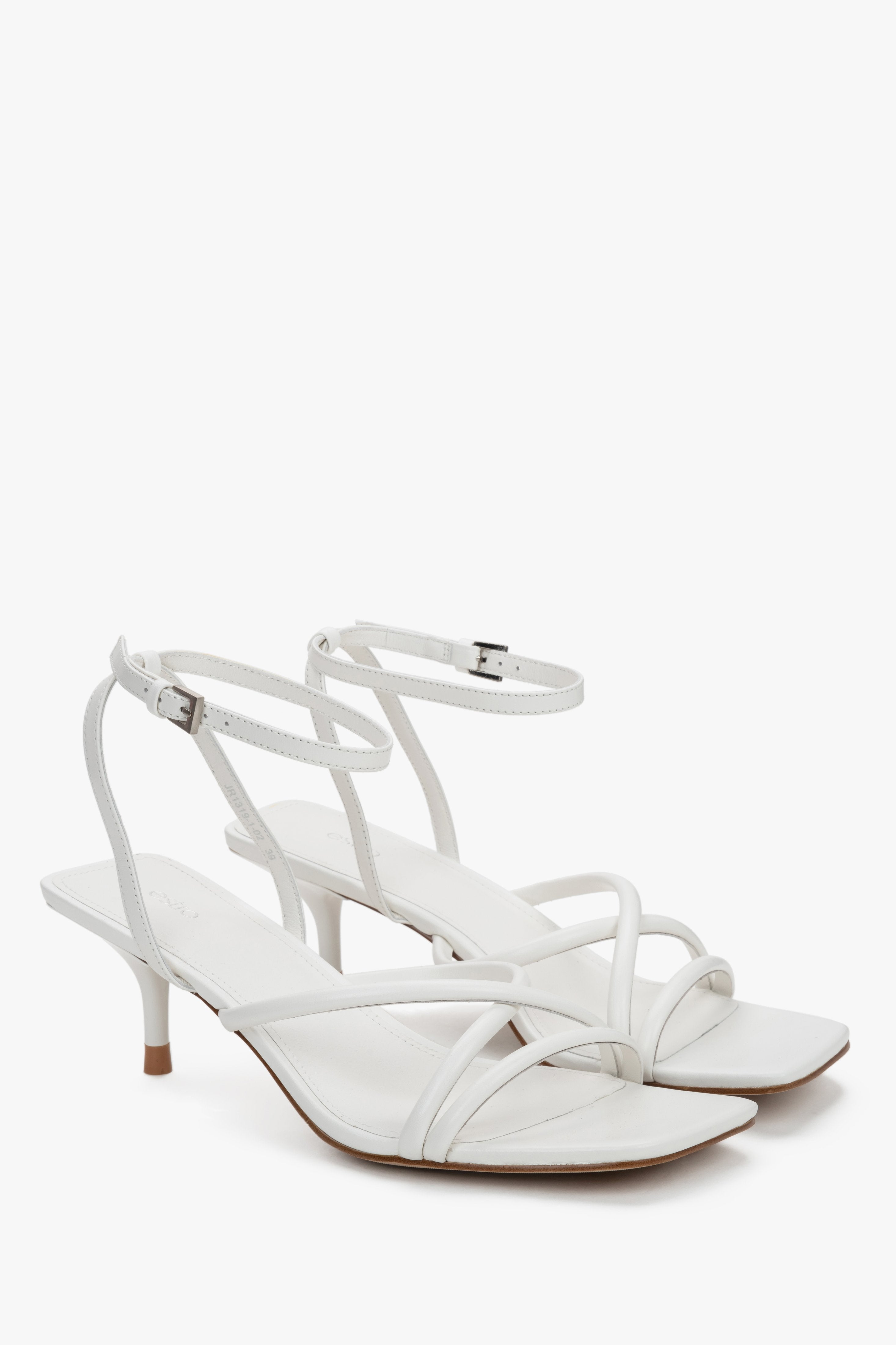 Side view of women's white leather sandals with slim stiletto heel.