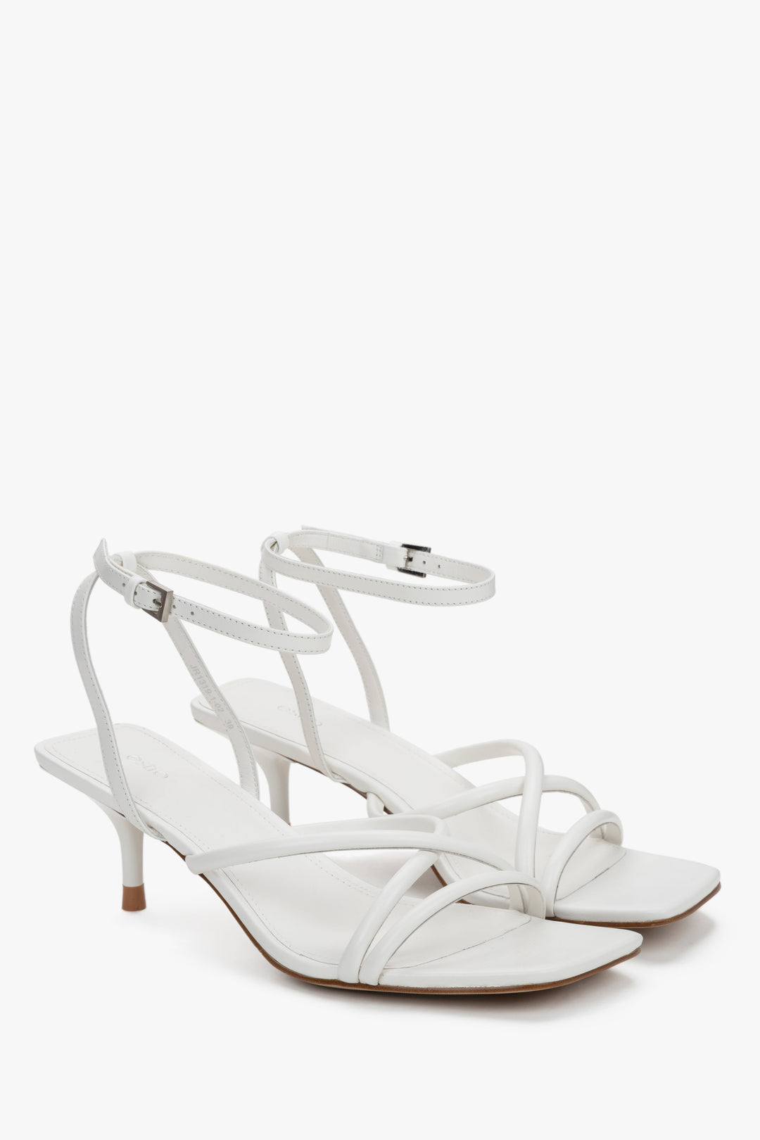 Side view of women's white leather sandals with slim stiletto heel.