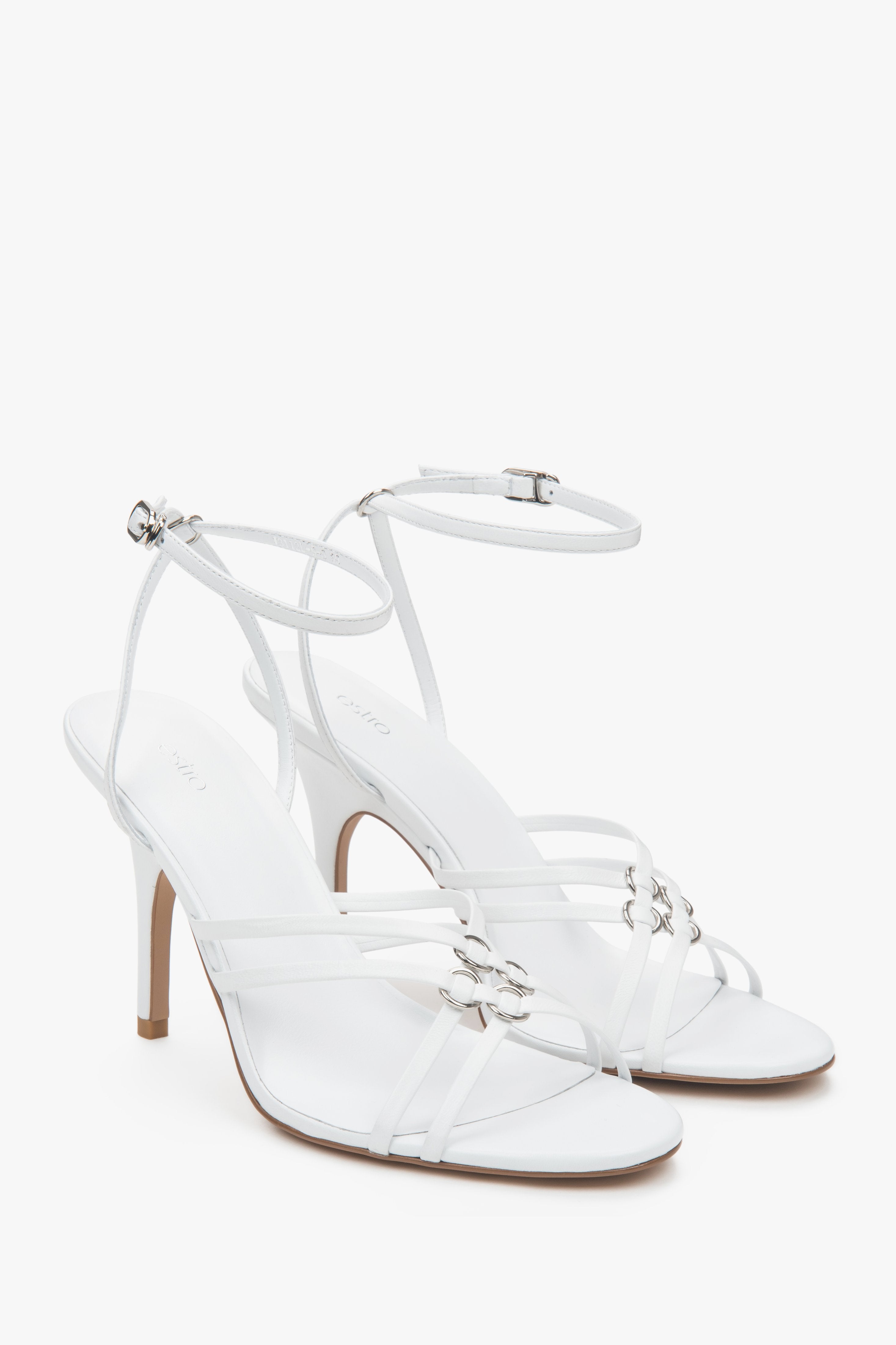 Women’s white leather stiletto sandals with silver details.