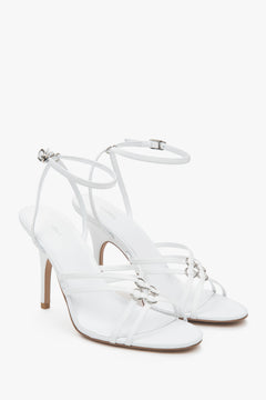 Women’s white leather stiletto sandals with silver details.