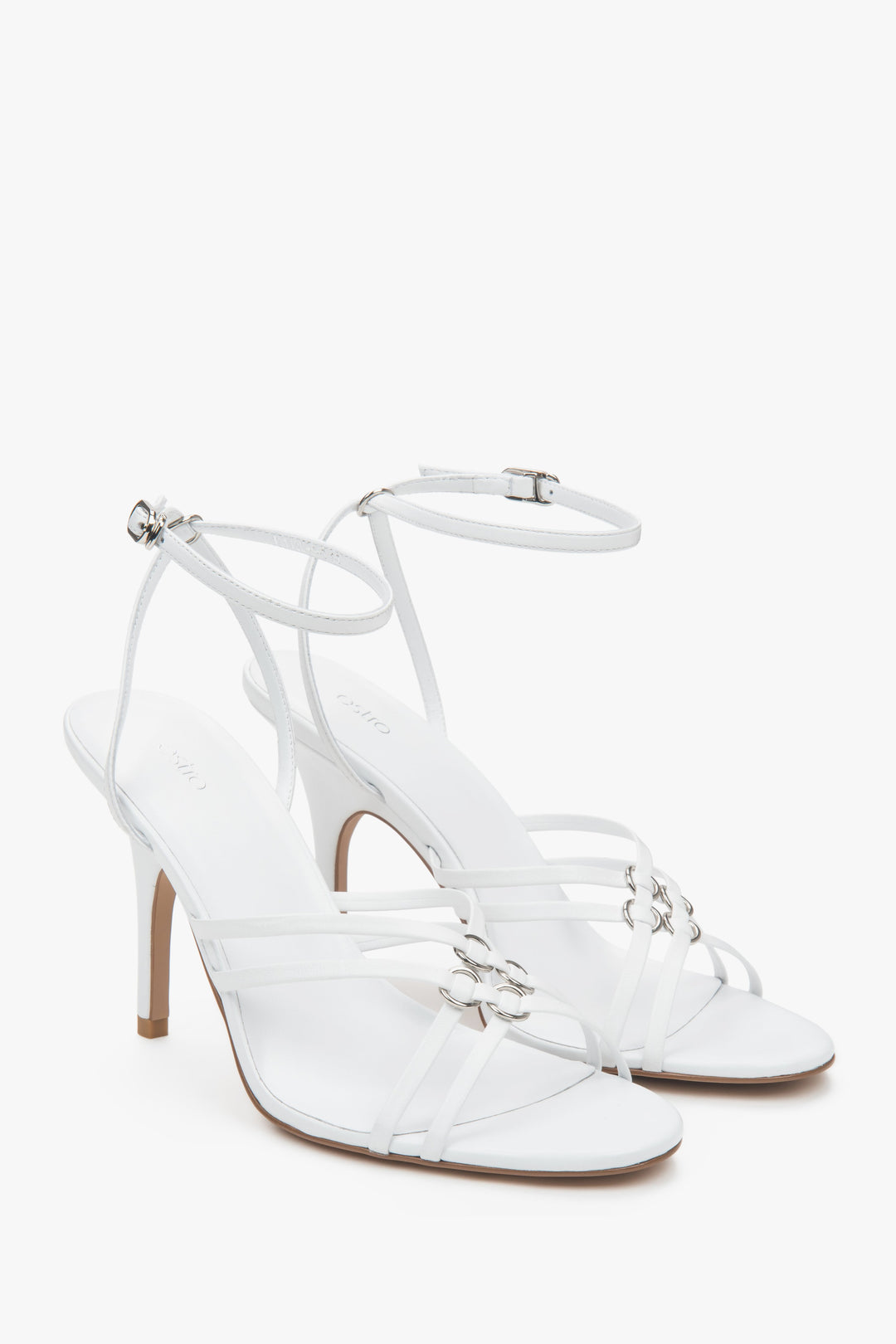 Women’s white leather stiletto sandals with silver details.
