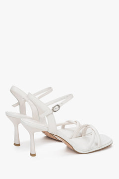 With a stiletto heel, white women’s leather sandals with thin straps by Estro.
