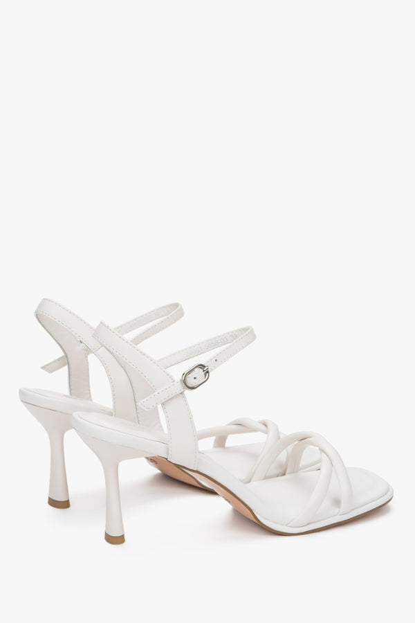 With a stiletto heel, white women’s leather sandals with thin straps by Estro.