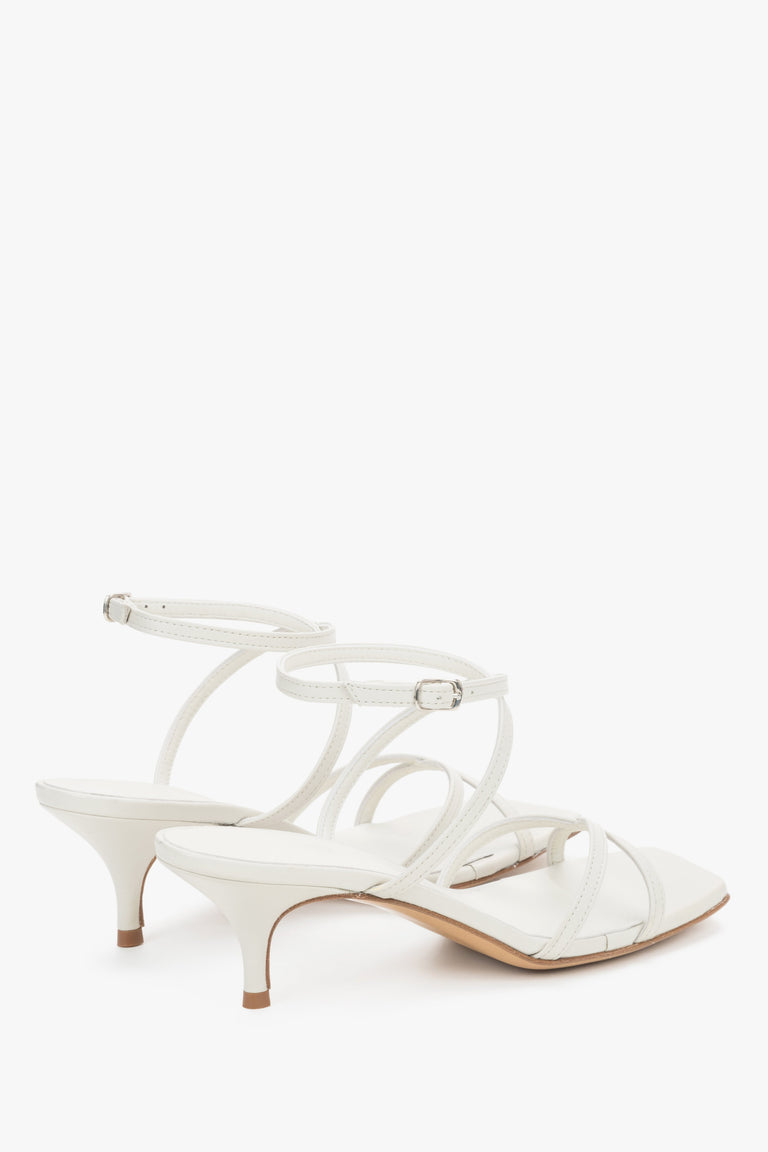 Close-up of the pristine white leather criss-crossing straps and stable flare heel.