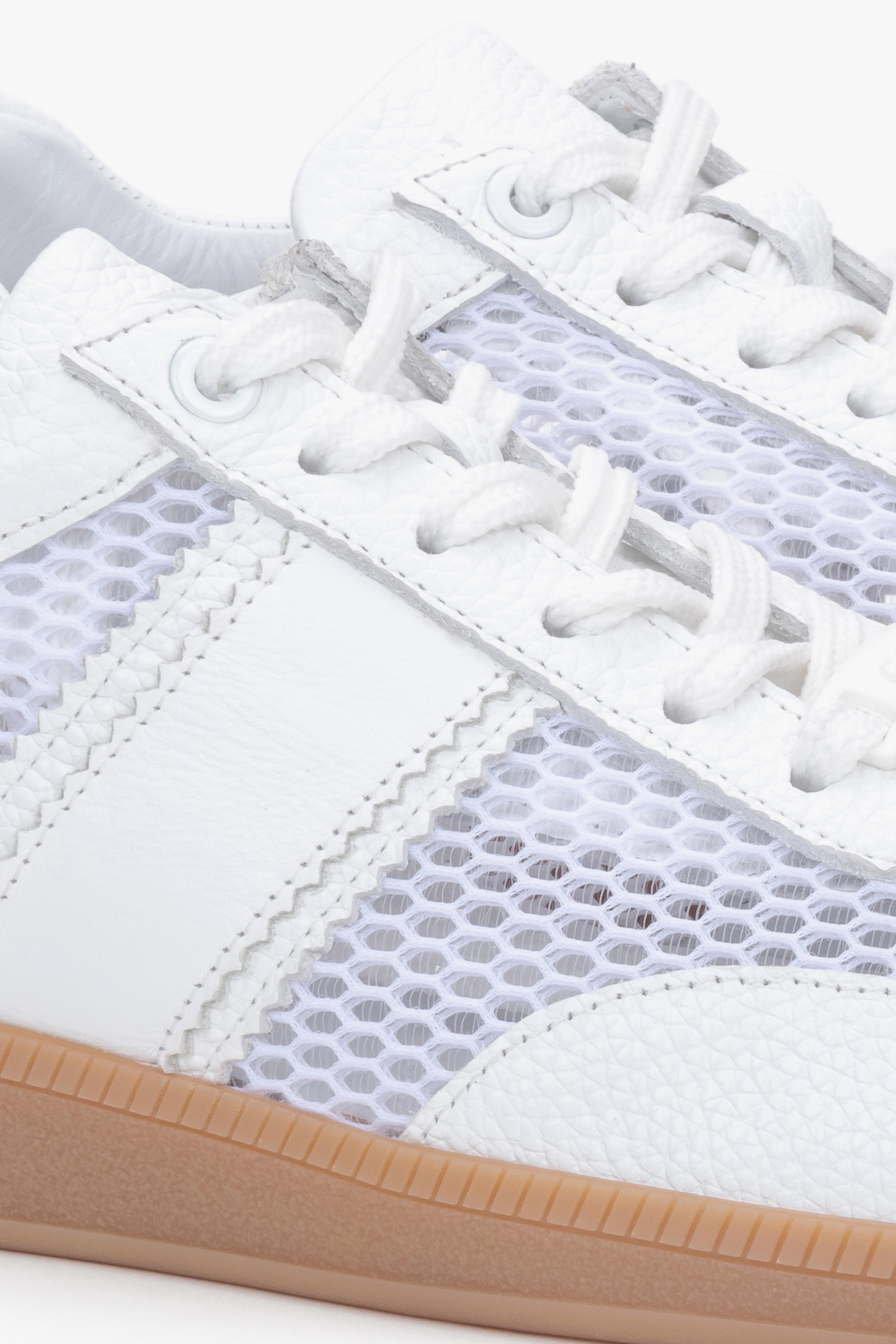 Close-up of white natural leather, velour, and mesh sneakers.