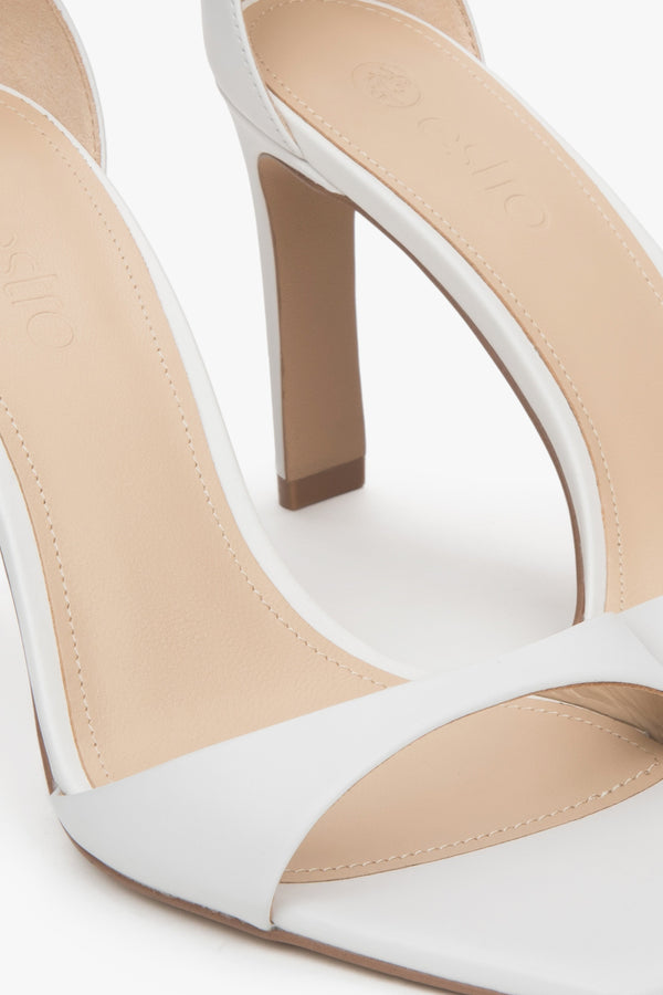 Women’s white sandals in patent natural leather on a stable block heel.