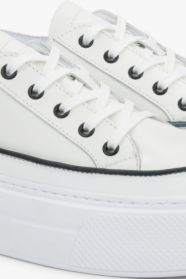 Detail view of the lace-up fastening and soft leather upper on white Estro sneakers.