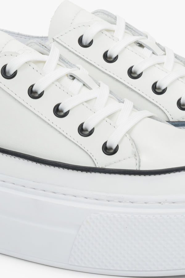 Detail view of the lace-up fastening and soft leather upper on white Estro sneakers.