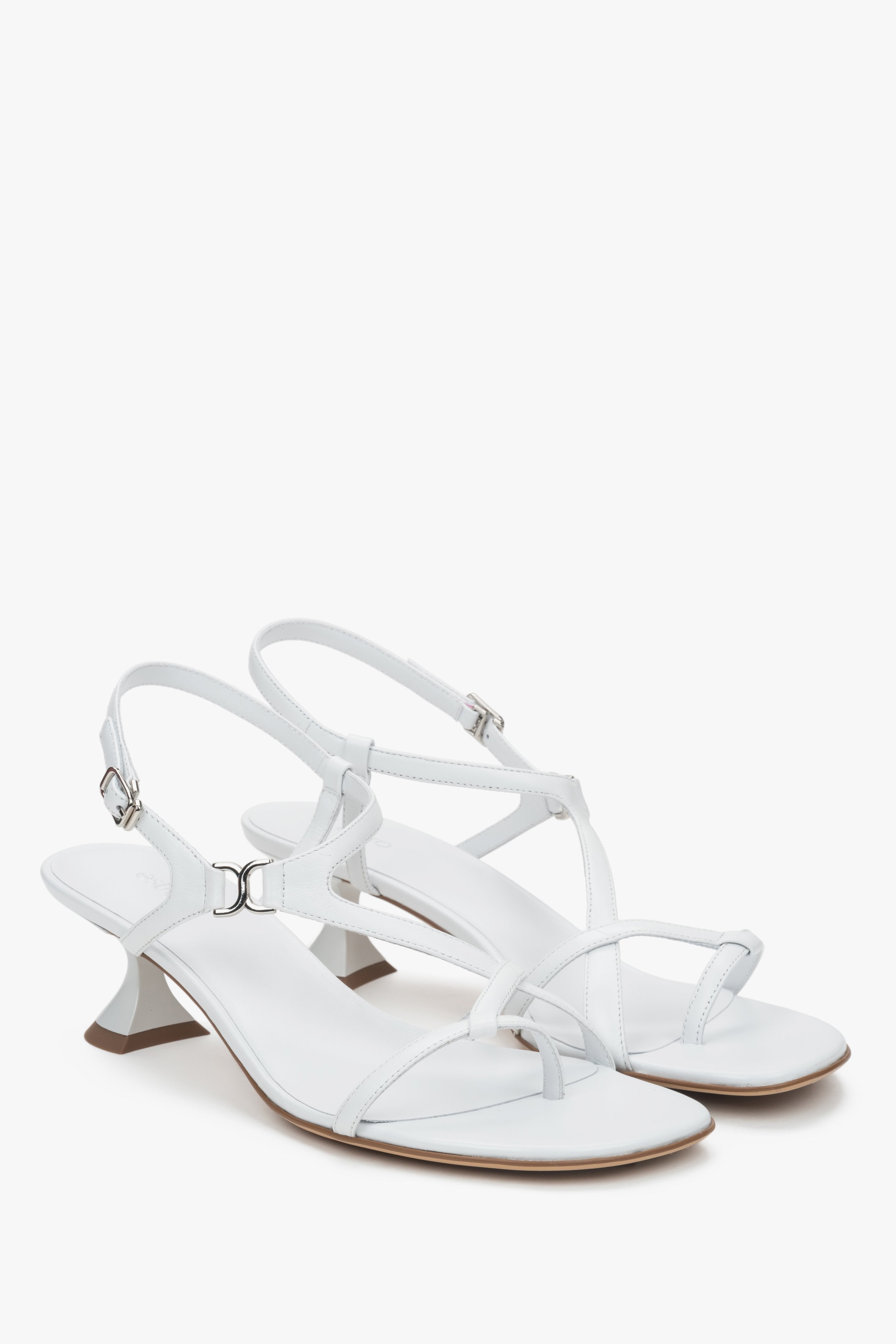White women’s sandals with a funnel heel and woven straps.