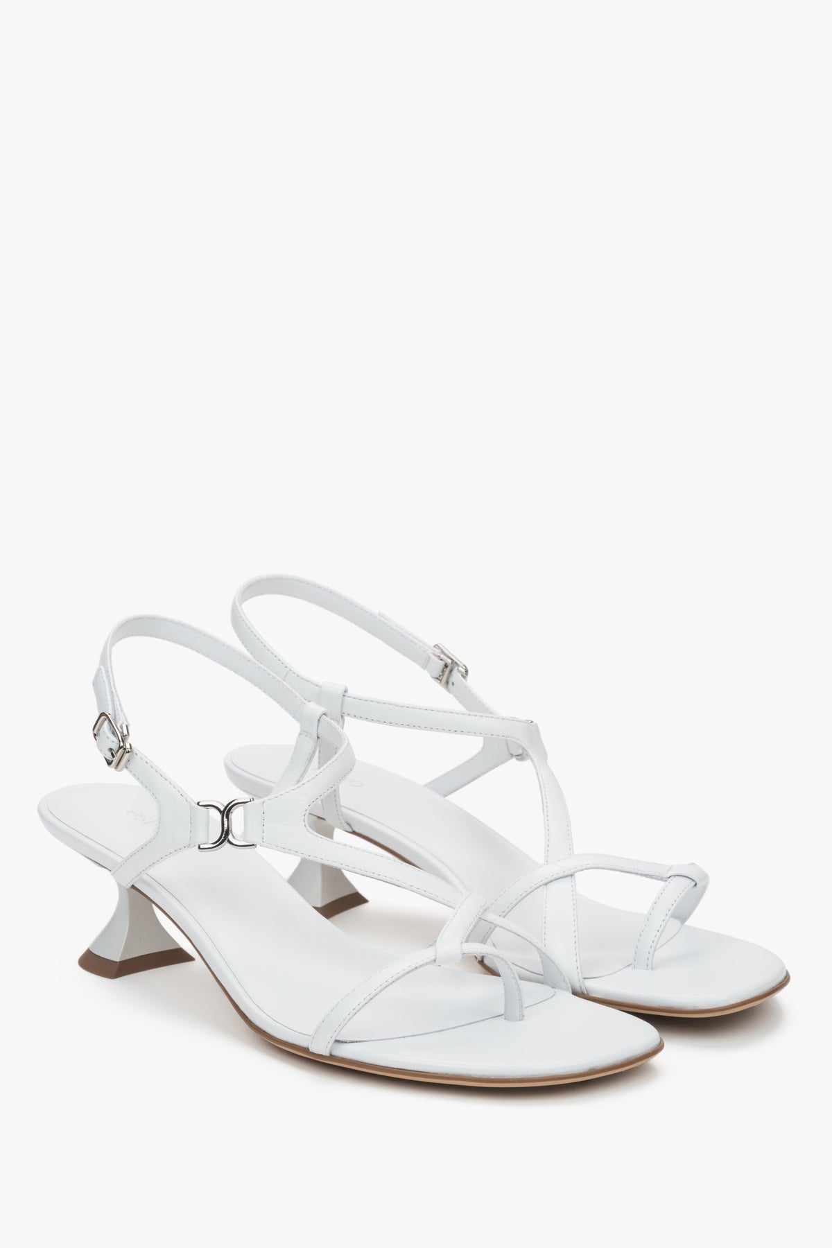 White women’s sandals with a funnel heel and woven straps.