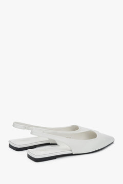 White slingback sandals with a pointed toe and flat heel.