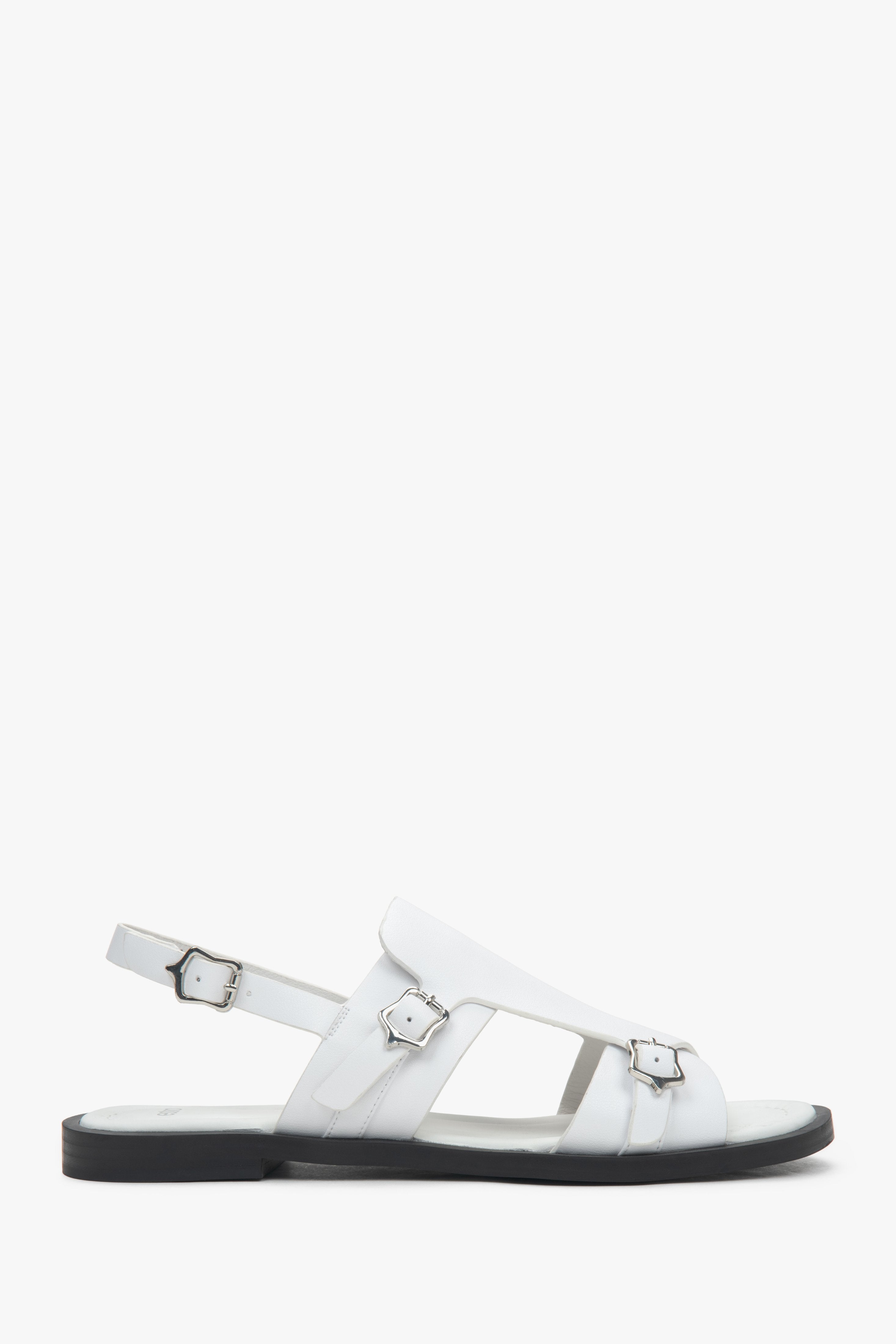 White closed-toe women’s sandals on a flat natural leather sole.