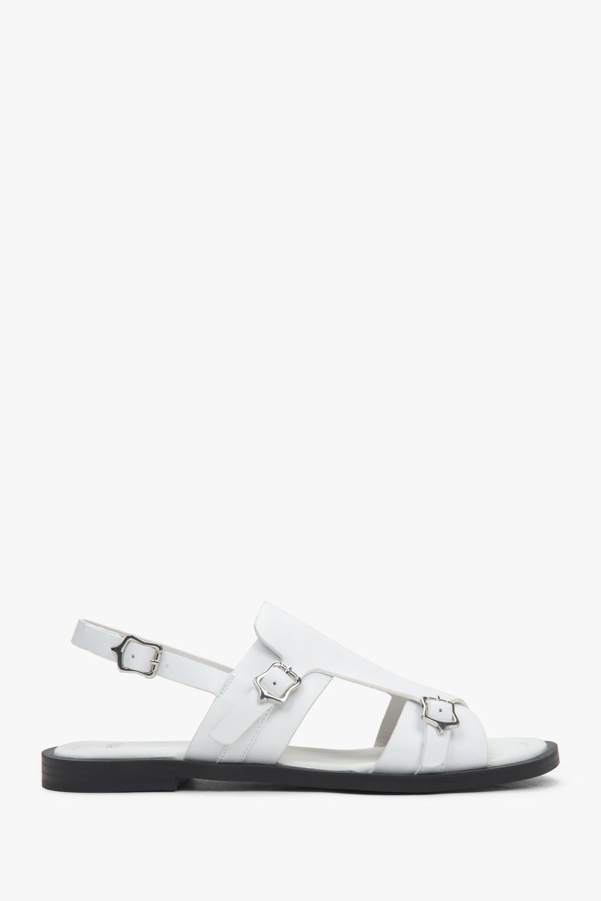 White closed-toe women’s sandals on a flat natural leather sole.