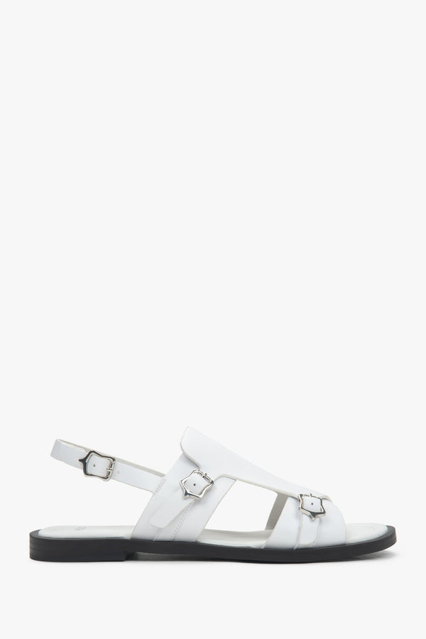 White closed-toe women’s sandals on a flat natural leather sole.