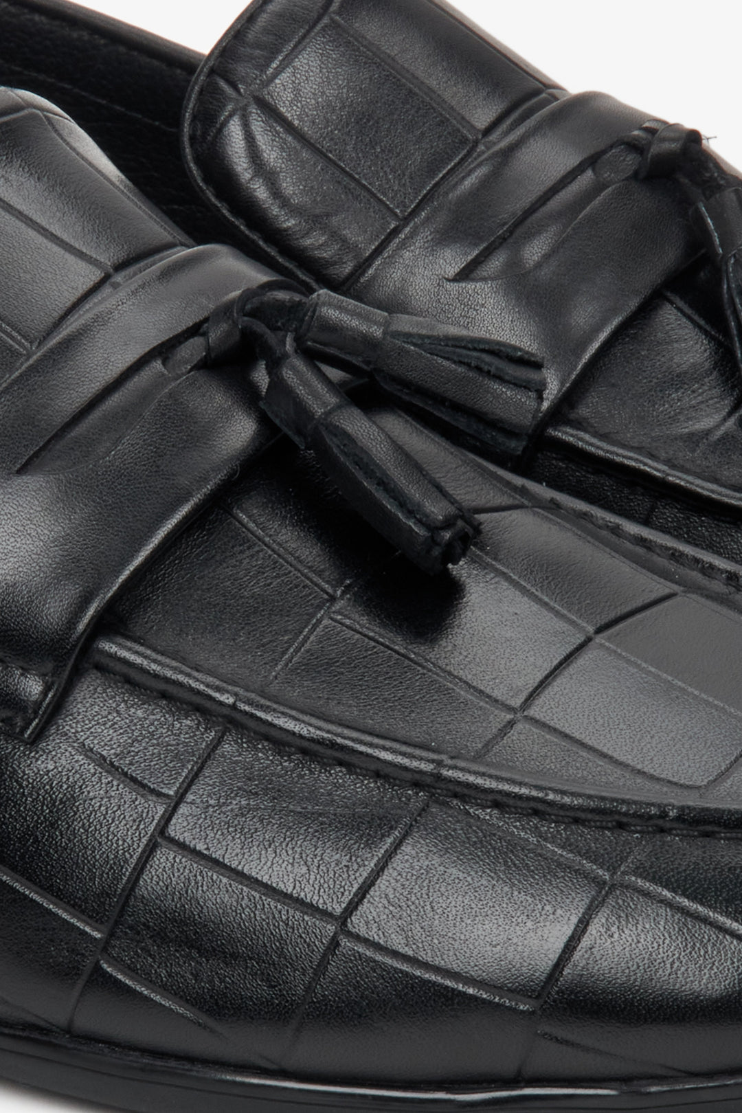 Men's black leather loafers - close-up of the texture of the material and embellishments.