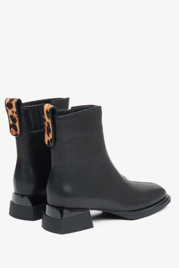 Black leather ankle boots for women with low heels and animal print inserts – close-up of the heel and side line of the shoes.