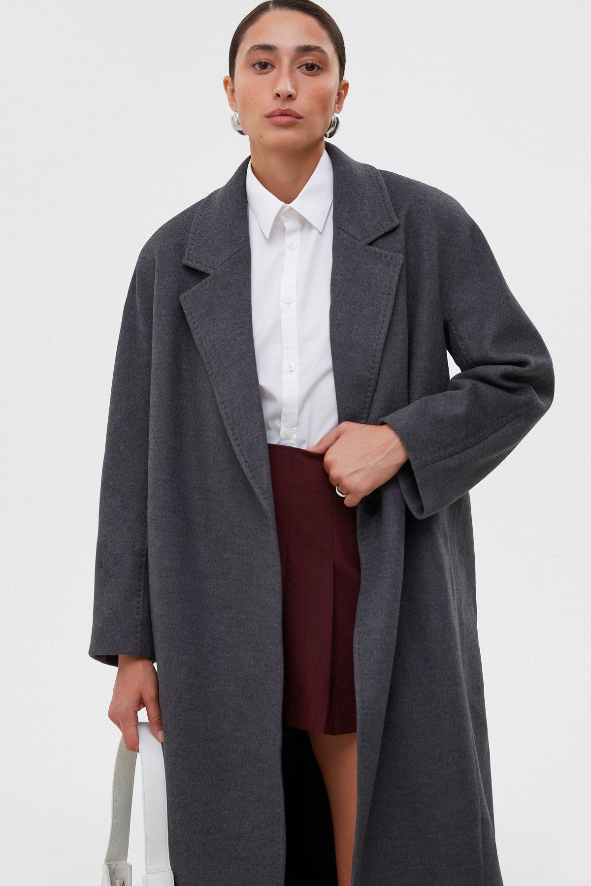 Women's grey coat by Estro tied at the waist.