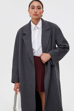 Women's grey coat by Estro tied at the waist.
