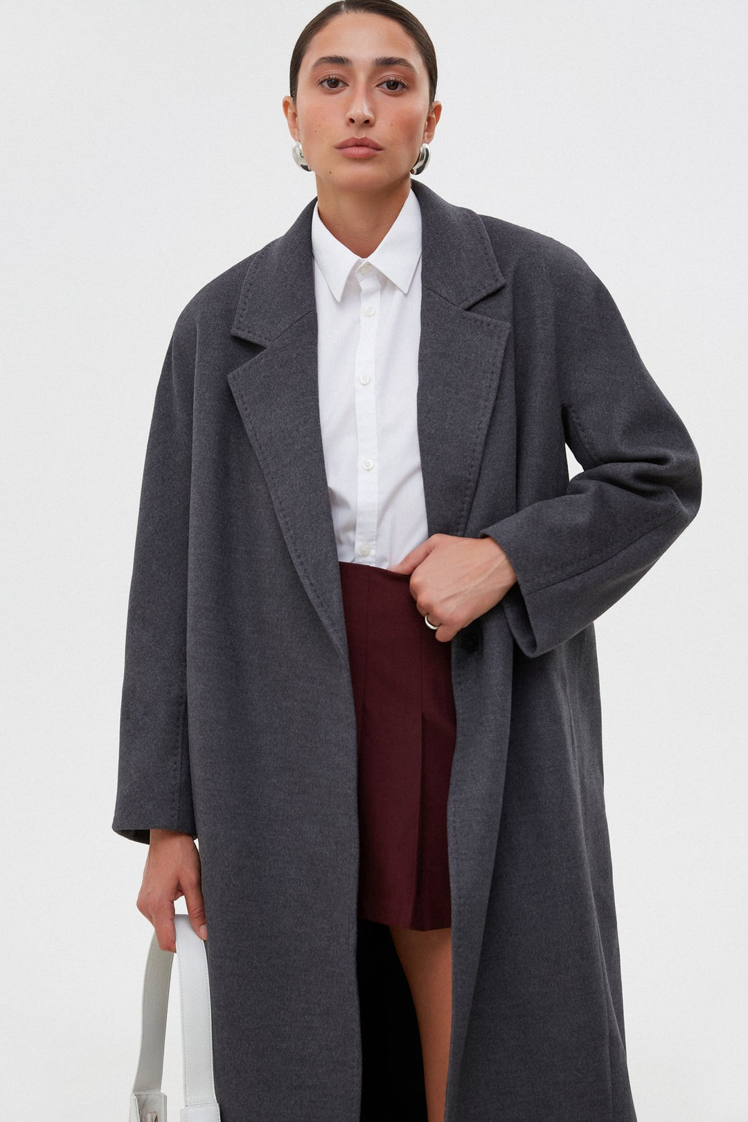 Women's grey coat by Estro tied at the waist.