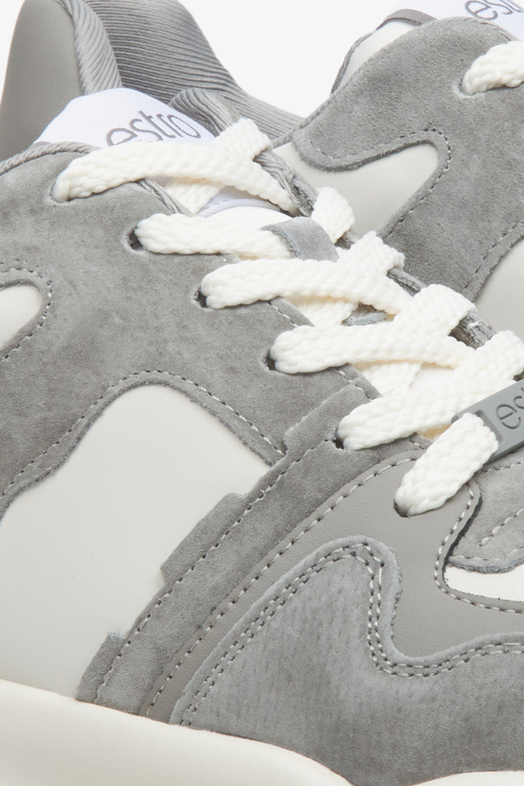 Women's grey and white sneakers - close-up on details.
