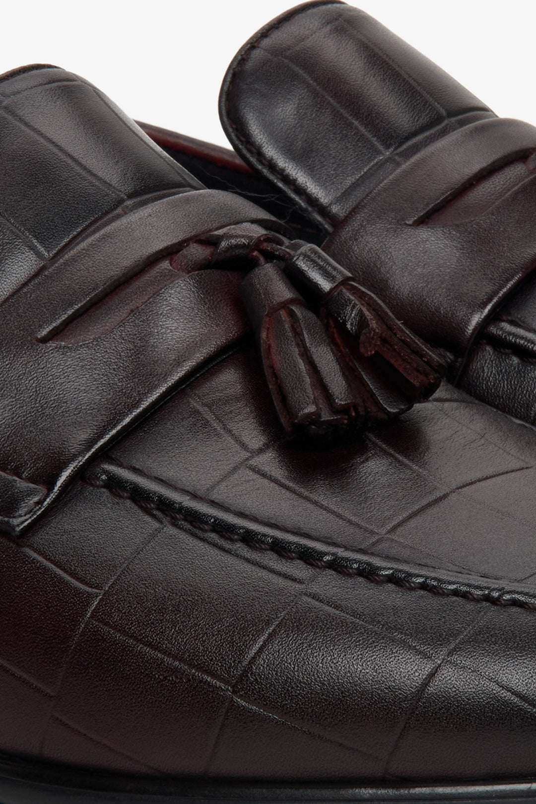 Men's brown leather loafers - close-up of the texture of the material and embellishments.