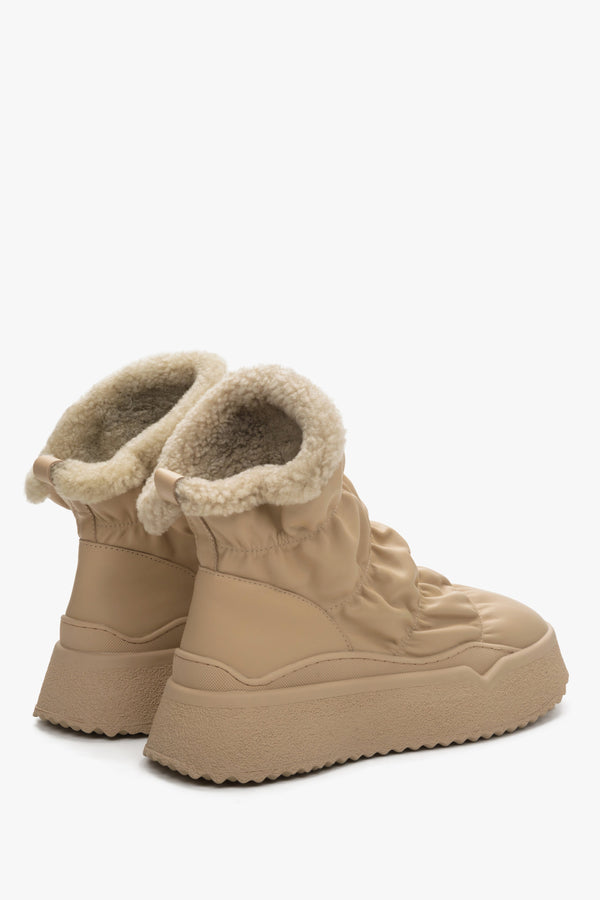 Women's beige snow boots, fur lined - close-up on shoe sideline.