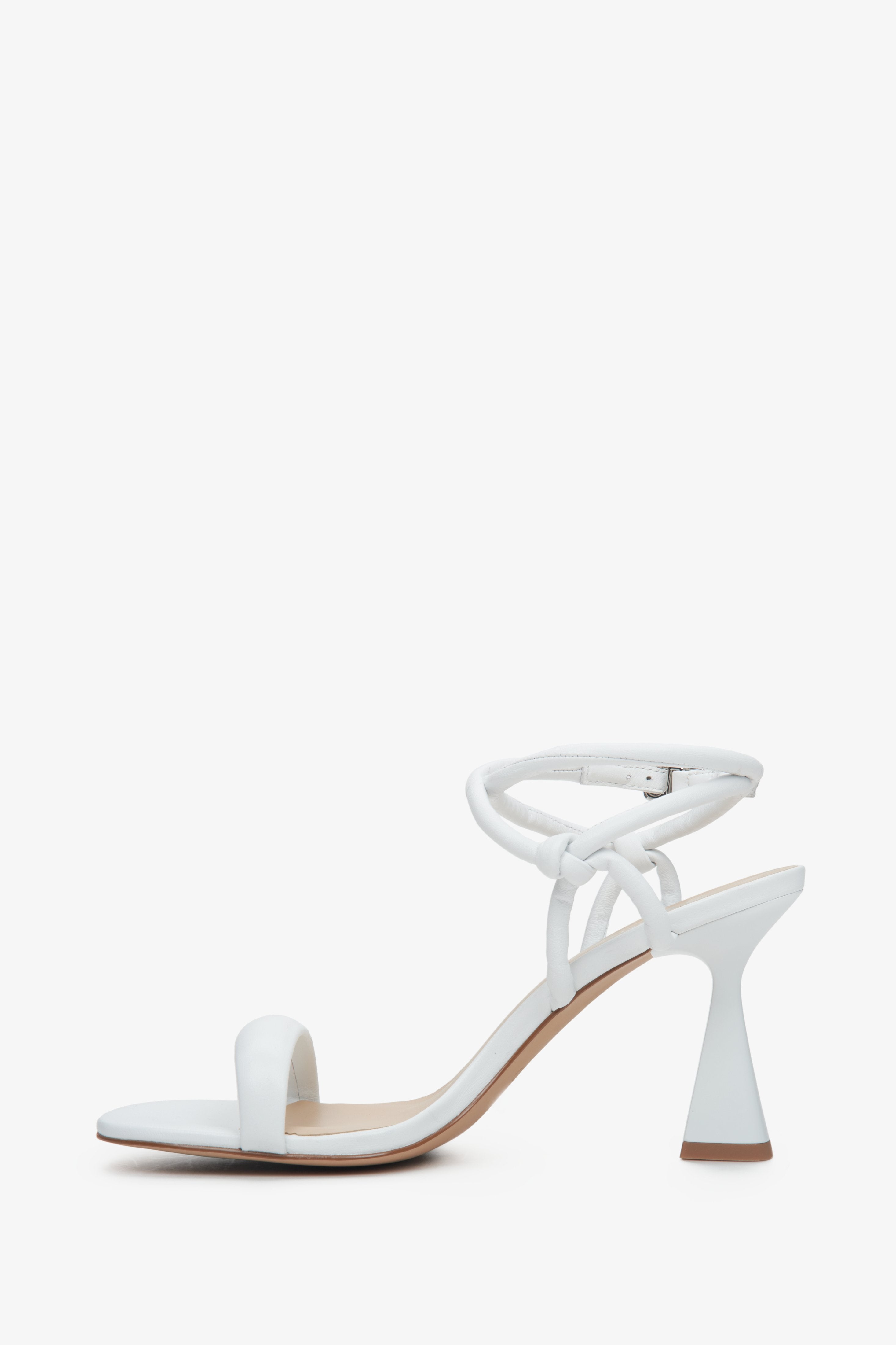 Women's white strappy sandals on a funnel heel - shoe profile.