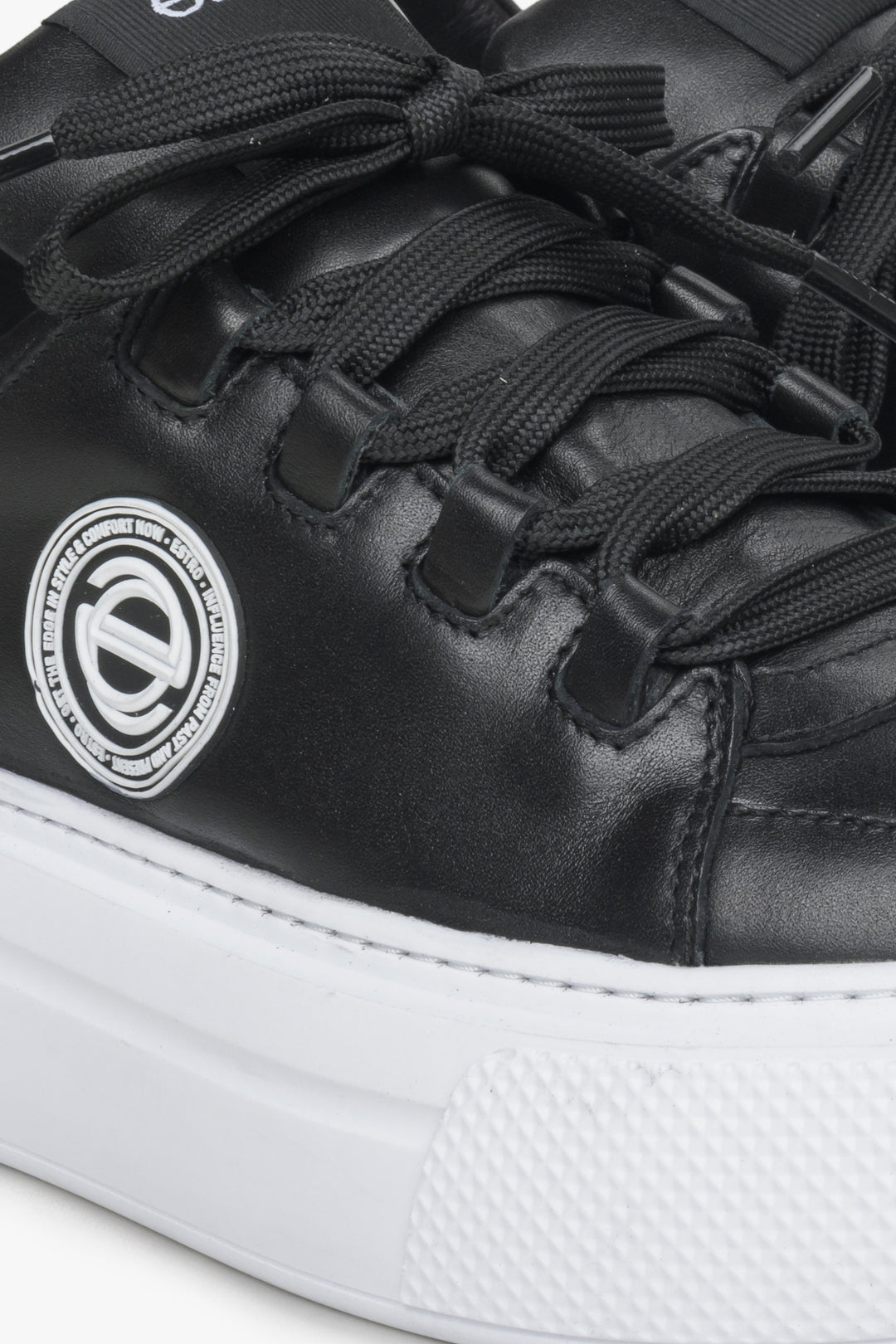 Women's black sneakers made of genuine leather - close-up on details.