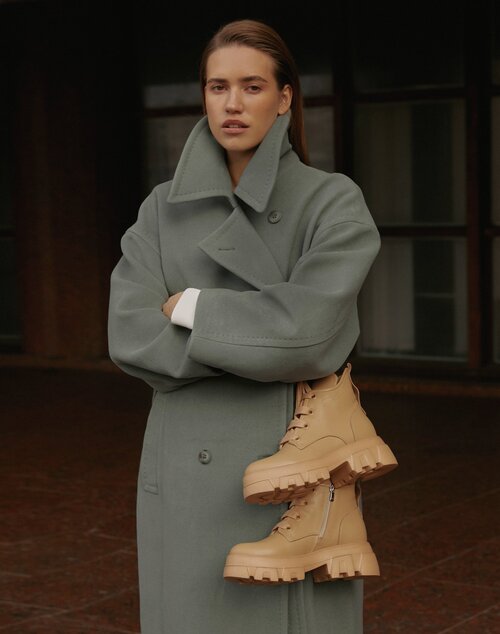 Brown, winter women's leather boots with insulation by Estro - presentation on a model.