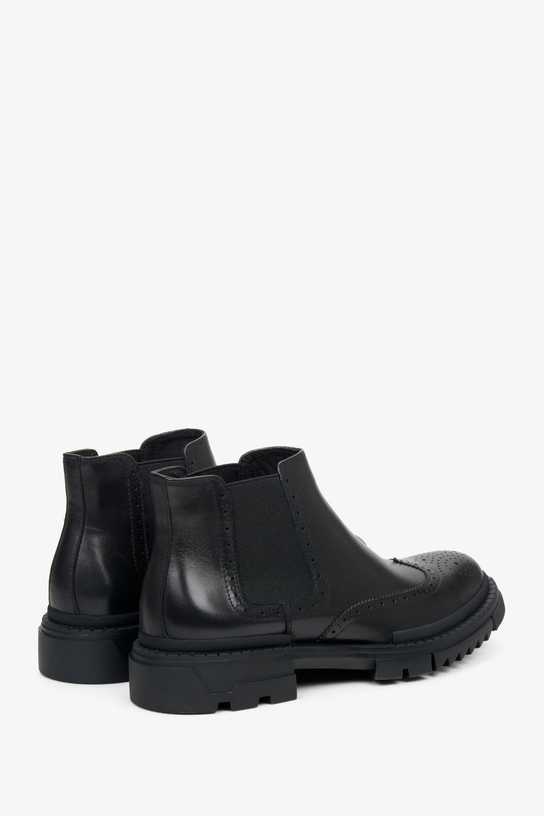 Men's low black ankle boots made of genuine leather - close-up on the side and back of the footwear.