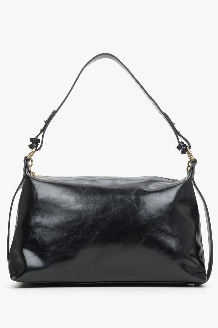 Large,women's  black handbag with decorative chain by Estro - back view of the model.