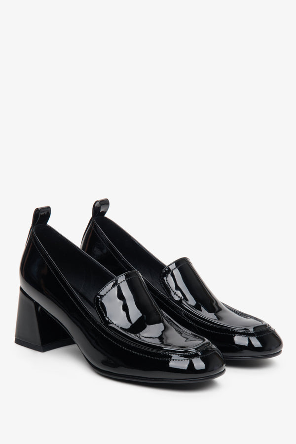 Women's black sleek loafers on a block heel.