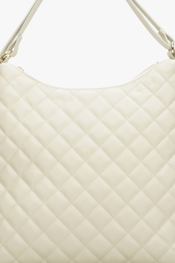 Women's light beige leather quilted handbag.