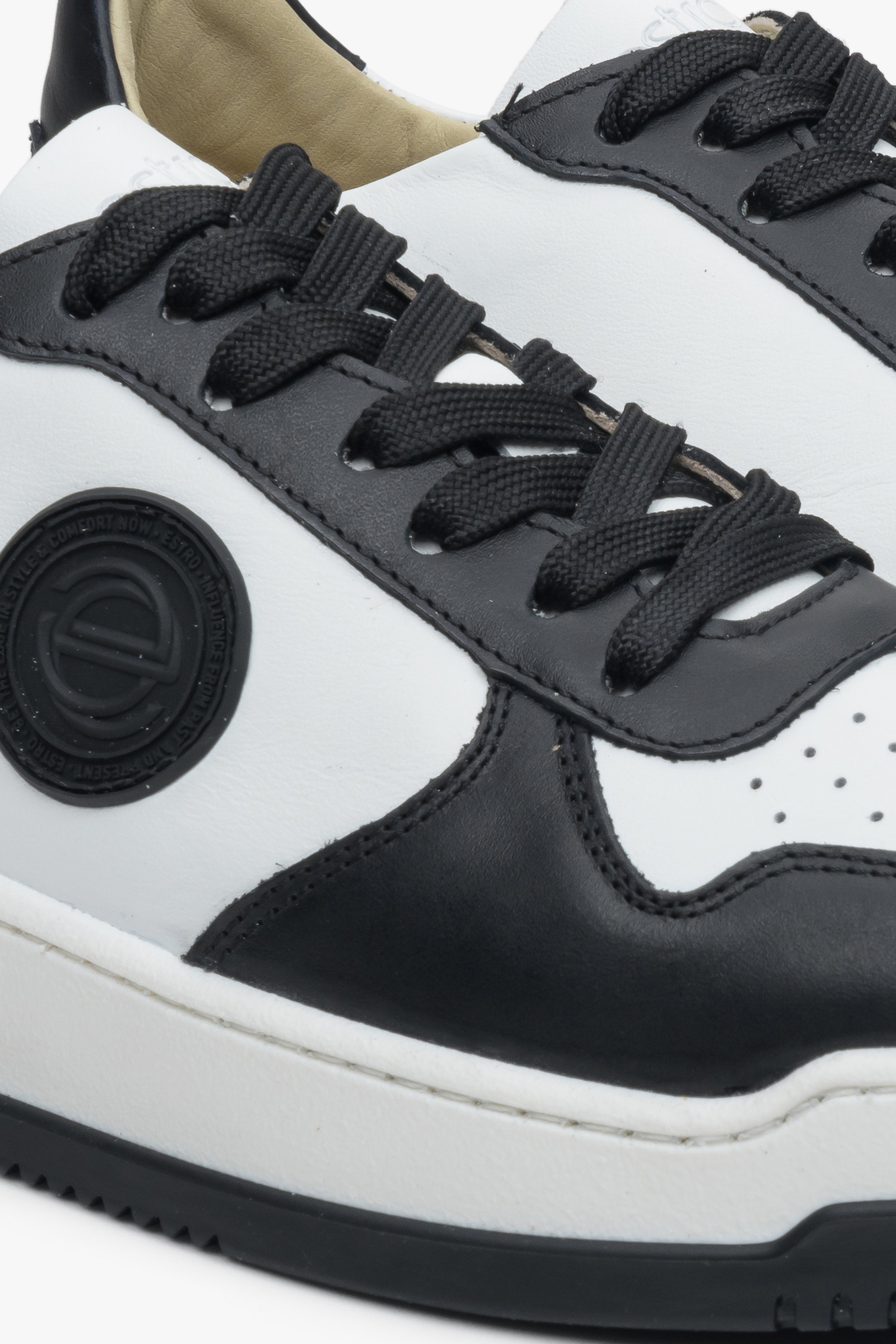 Leather women's sneakers by Estro in black and white color with laces - close-up on the details.