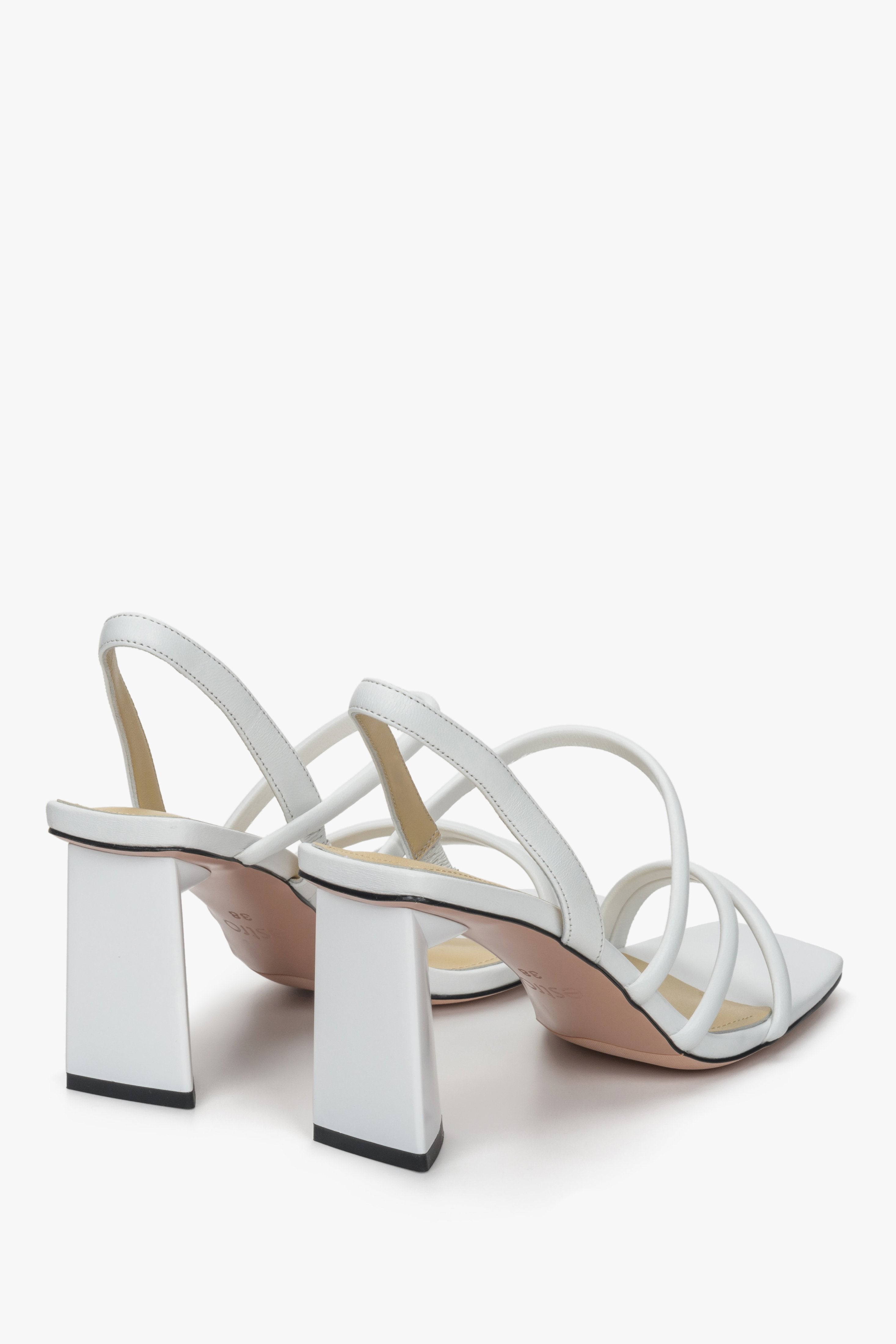 White strappy women's leather sandals on a block heel - a close-up on the bottom line.