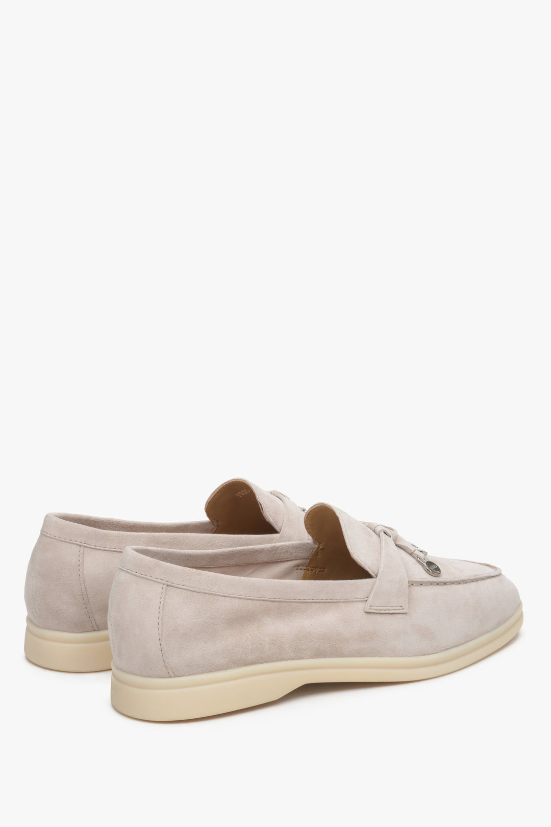 Light beige women's loafers made of natural velour and leather - close up on heel counter.