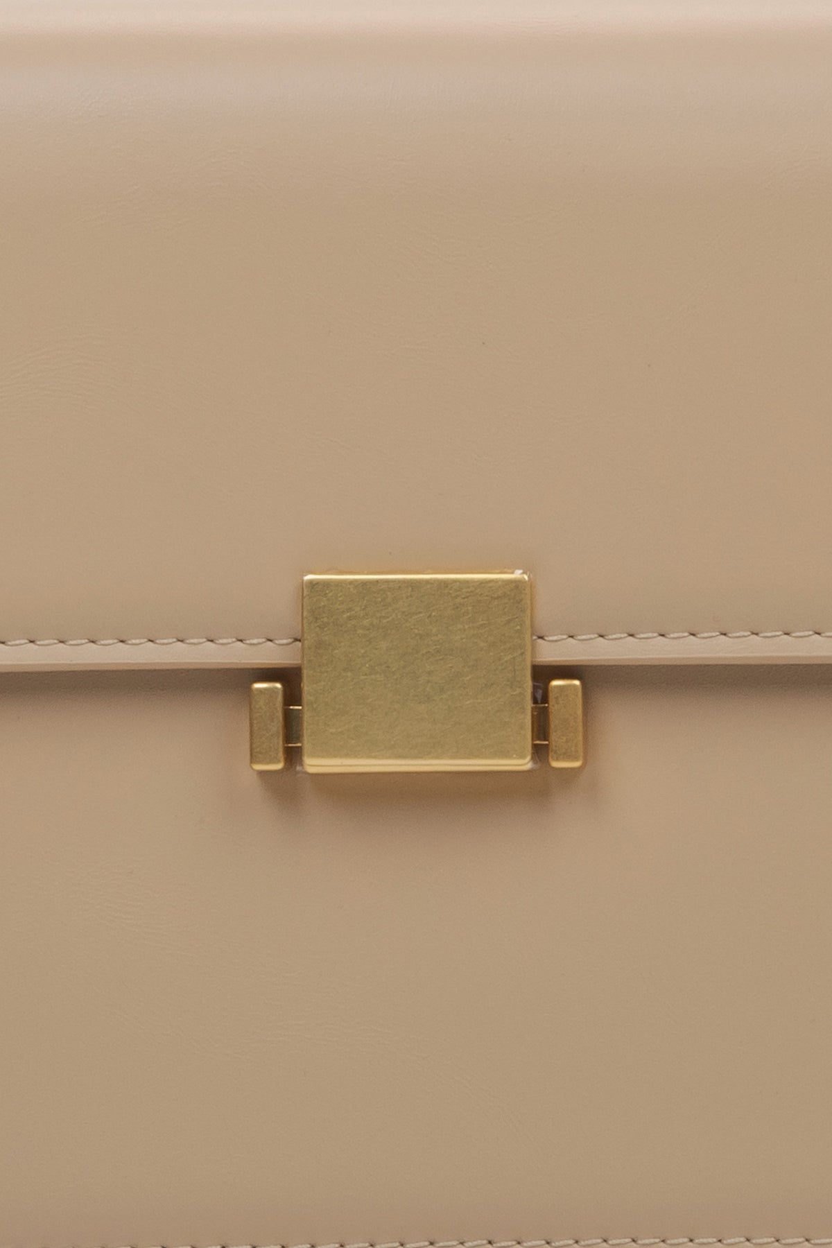 Women's beige handbag - close-up of the snap closure.