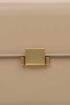 Women's beige handbag - close-up of the snap closure.