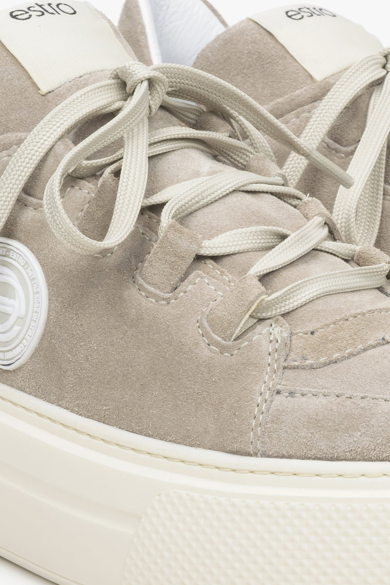 Women's beige sneakers made of genuine velour - close-up on details.