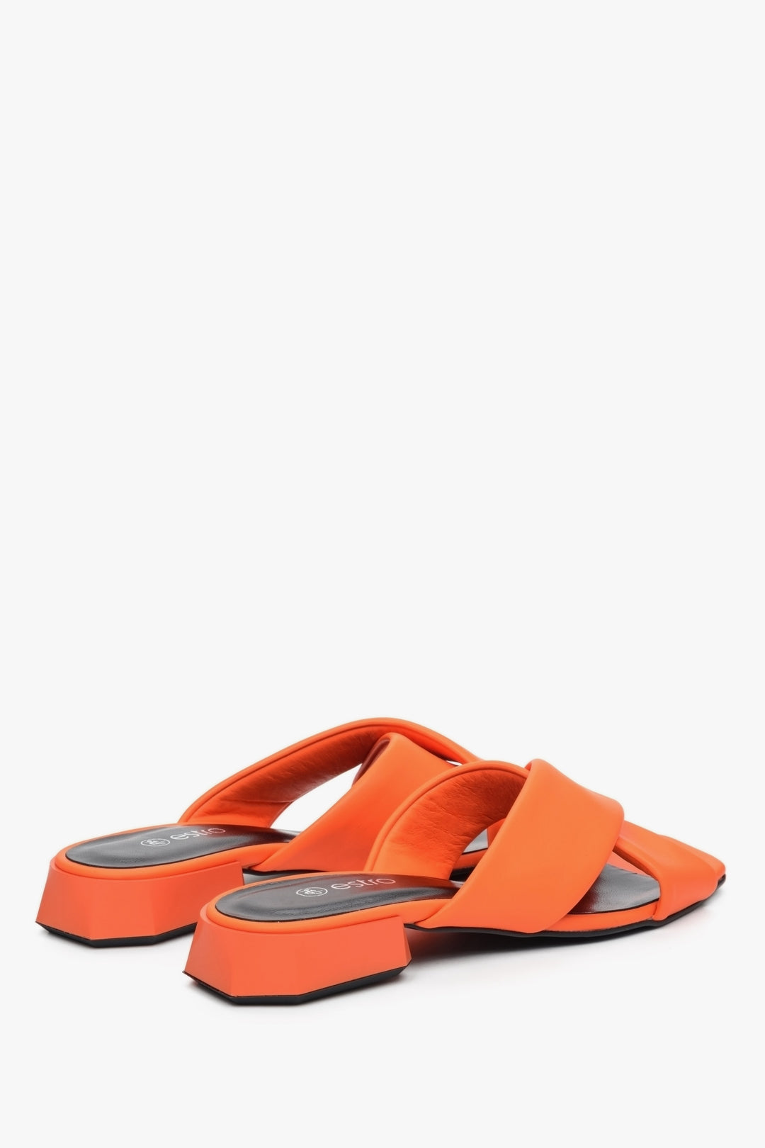 Women's low-heeled leather mules in orange - close-up on back tip of the shoe.