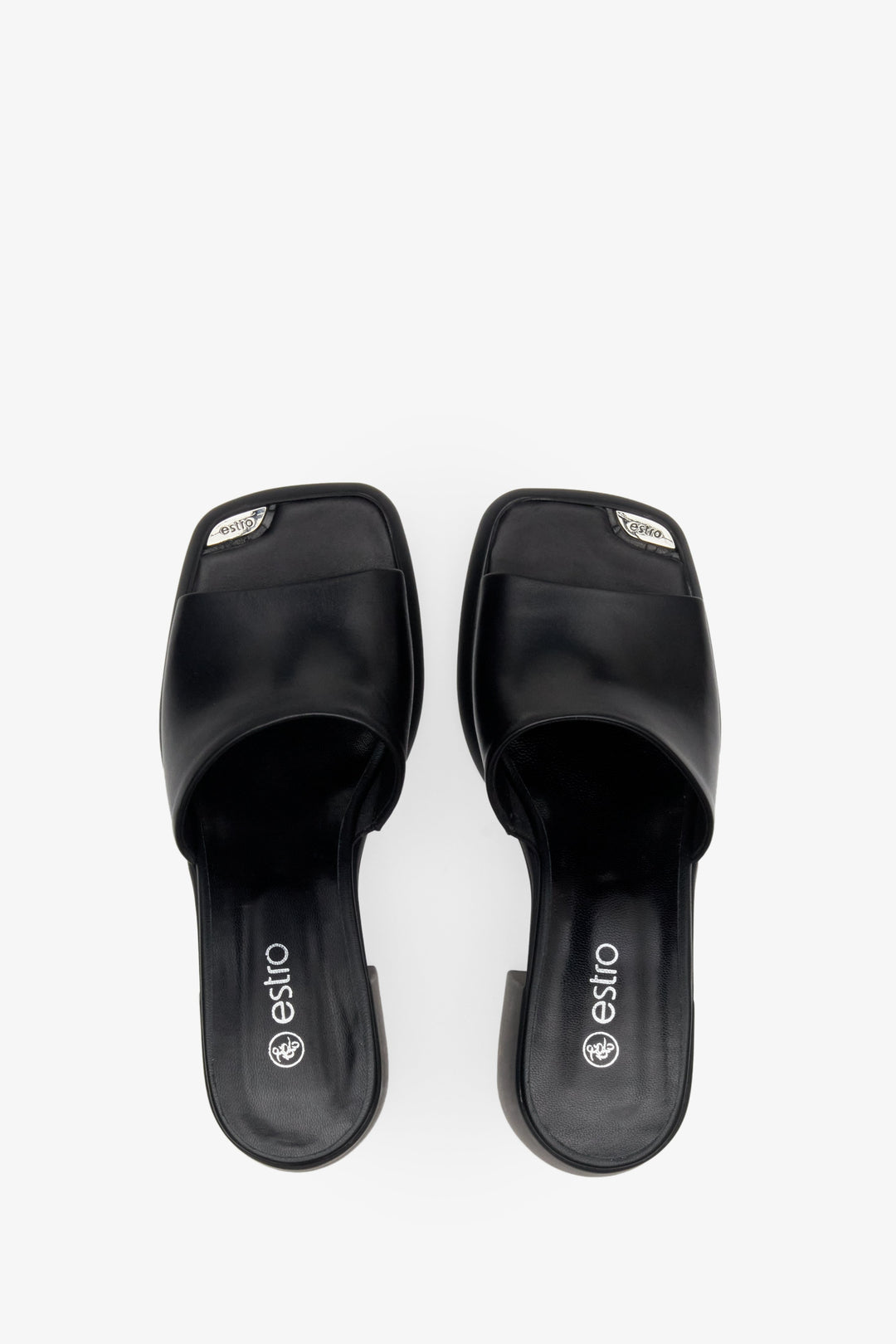 Women's mules in black color with block heels - presentation of footwear from above.