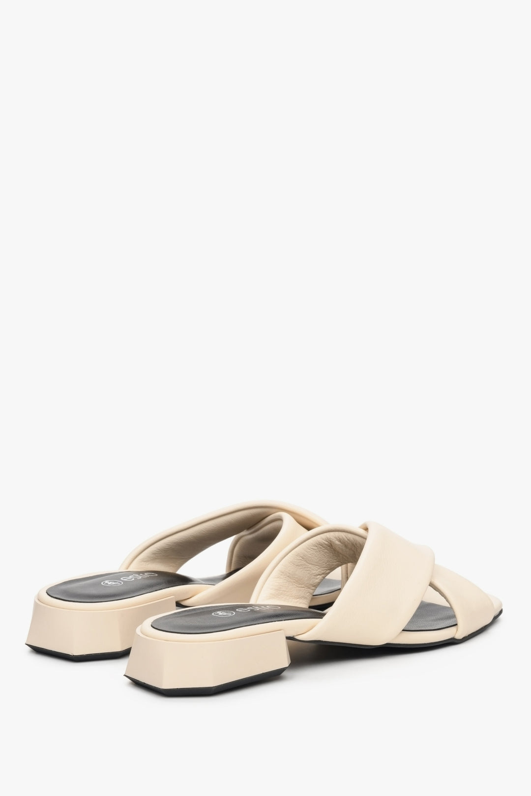 Women's low-heeled leather mules in beige - close-up on back tip of the shoe.